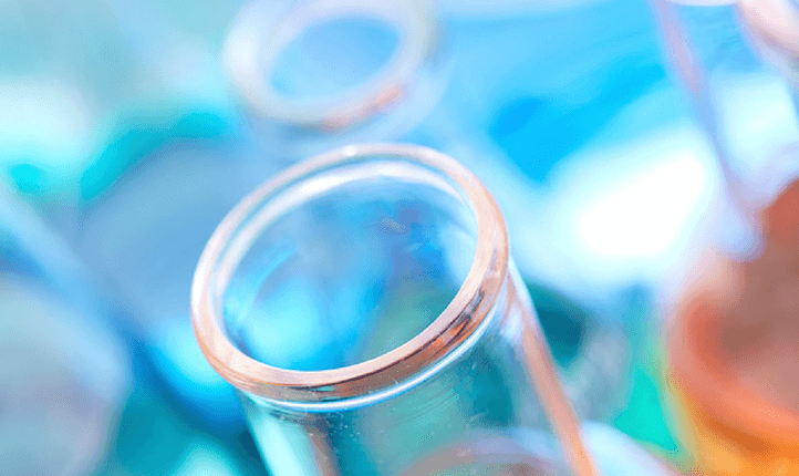 A close-up of various test tubes and chemical beakers